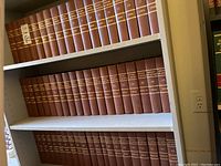 Three white shelving units filled with brown bound Ontario Law Reports volumes