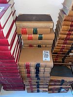 Stack of bound law books titled 'Ontario Weekly Notes' with tan covers and red and blue spine labels showing various years including 1958 and 1946.