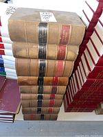 Stack of large hardcover law books with worn brown cloth bindings and red and black spine labels showing years and courts