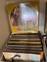 Side photo showing a large stack of assorted LP records with the visible cover of "Today's Million Sellers" album on top.