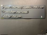 Full view of neon sign on backboard, shows entire text layout.