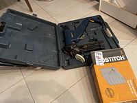 Mastercraft commercial staple gun tool inside molded plastic carrying case next to a box of floor staples.
