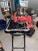 Front view of Husky tile saw mounted on metal stand, showing red saw housing and cutting blade guard.