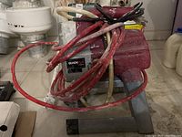 Front view of Titan XT 250 electric sprayer on stand with attached hoses and spray gun