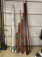 Full view of the lot showing dowels, curtain rods and dark edging strips leaning against a wall