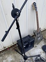 Overview of guitar leaning against wall with Vox amp and mic stand