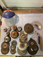 Full spread of wire brushes, abrasive stones, and safety face shield arranged on a light blue quilted surface.