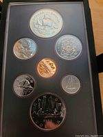 Photo showing the front side of the coin set with the commemorative Griffon dollar coin prominently displayed along with other Canadian coins.