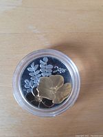 Reverse of 2005 Canadian 50 Cent coin showing a gold plated flower design with leaves and 2005 year marking.