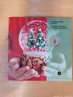 Front cover of the 2007 commemorative coin set featuring a snow globe with Christmas trees and the Royal Canadian Mint logo.