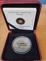 2014 Canadian 25 cent coloured coin featuring Tiktaalik in display case with certificate of authenticity above.