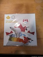 Photo of original packaging featuring polar bear, maple leaf, and a flying Canada goose, with a map of Canada colored in various shades.