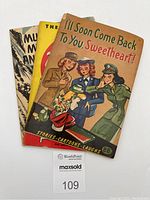 Three vintage paperback books stacked with illustrated military-themed covers.