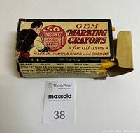 Top and side views of a worn vintage cardboard box labeled as Socony Gem Marking Crayons with 12 yellow crayons partially visible inside.