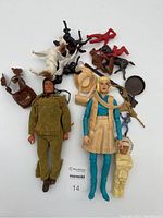 Overview of all items including Jane West and Tonto action figures, small child figure, two plastic horses, hats, rifle, and small plastic figures laid out on a white background.