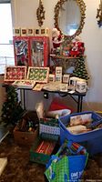 Full lot view showing stacked boxes and bins of Christmas decorations including trees, dolls, and ornaments.