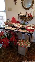 Photo of the table with Christmas dishes, linens, and decor including plates, cups, linens, and Coke glasses