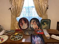 Full view of Coca-Cola trays, state plates, Disney World tin plate, Shell candy dish, coupon organizer, wood key holder and bowl on wooden table against window