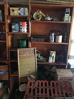 Fireplace grate, washboard, utility pump box, fan, work lights and bag of coal displayed on shelves, showing multiple items in the lot.