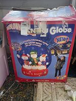 Photo of the original box for the Airblown inflatable snow globe showing snowmen inside a globe with 'Let it Snow' text, lights up and snow effect described.