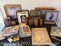 Wide view of assortment of framed pictures, photo albums, and artwork showing various frame sizes and finishes