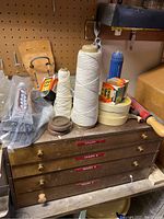 Photo of wooden 4-drawer organizer with string spools, glue, and miscellaneous items on top