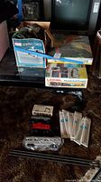 Overview of table showing Lionel Thunderball Freight box, sewing chest box (not included), train cars and track packs