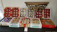 Full view of all vintage glass Christmas ornaments in their original packaging on display, boxes containing red, silver, and assorted color ornaments.