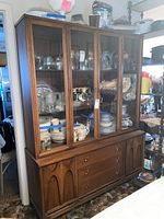 Front view of entire hutch showing glass doors, lower drawers and side cabinets.