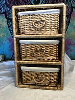 Front view of wicker basket chest with three stacked baskets and fabric liners.
