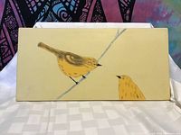 Front view of the rectangular ceramic tile showing two yellow birds on a branch against a pale yellow background.