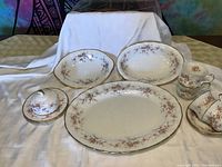 Full set of Paragon Victoriana Rose china pieces displayed on cloth background including teacups, saucers, plates, butter cover and serving bowls