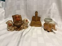 The full lot including the monkey trio, the Big Ben figurine, and the elephant egg cup displayed on white fabric.