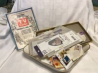 Photo showing white dresser tray filled with assorted postage stamps and paper pieces, with 1963 TV Guide partially visible behind