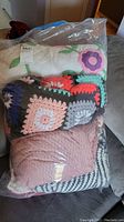 Full view of the sealed plastic bag containing the four blankets/quilt as folded inside the bag
