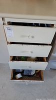 4-drawer white cabinet with all drawers open showing contents