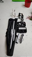 Overview of all items on white floor: lights, stands, cases and accessories
