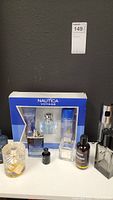 Overview photo of the men's cologne lot showing various bottles and Nautica Voyage gift set