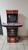 Full view of NBA Jam arcade basketball game machine, showing overall cabinet with artwork and controls.