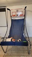 Pop-A-Shot basketball game with two hoops and multiple basketballs included on the game base.