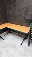 Rectangular classroom table set in corner with wood-like surface and modesty panel.