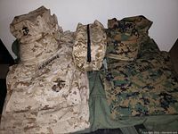 Photo showing folded desert and woodland blouses, desert toiletry bag, and green seabag.