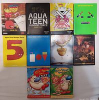 Top view of 8 Aquateen Hunger Force DVDs and 2 Ren & Stimpy DVD sets showcasing front cover art of vibrant cartoon characters and titles.