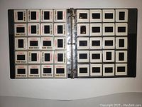 Black binder with transparent sleeves holding numerous Kodachrome medical slides, showing front pages with Kodak branding.