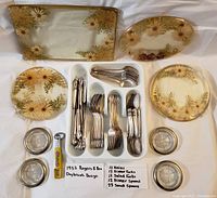 Overview of the entire lot displaying the 4 lucite/acrylic dried flower trivet trays, the Rogers & Bro 1952 Daybreak pattern silverware set arranged by type in compartments, the 4 vintage glass coasters, and the mid-century bottle opener with yellow handle and pink rose design.
