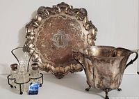 Lot showing sterling caps cut glass cruet set with salt and pepper shakers, silverplate monogrammed tray, and silverplate planter