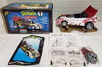 Spawn Mobile vehicle displayed with packaging, comic, instruction manual, and accessories on a cloth background.
