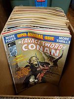 Box filled with vintage Conan magazines featuring a super annual issue on top with illustrated fantasy cover.