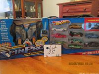 Photo showing the Spin Pro remote control car in packaging to the left and Hot Wheels 10 diecast car set to the right