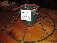 Front view showing the circular green metal base with zigzag supports and central cylindrical holder.